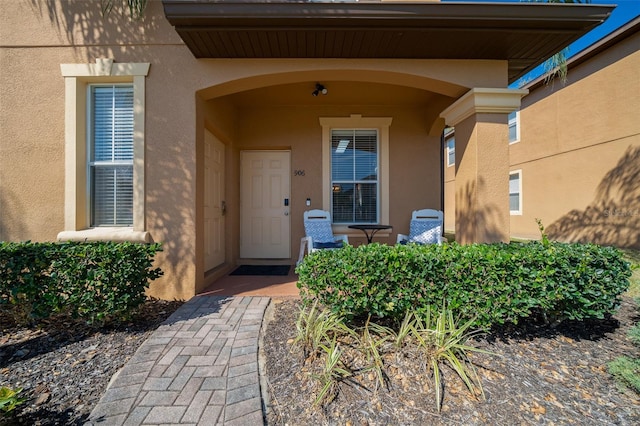 doorway to property featuring stucco siding