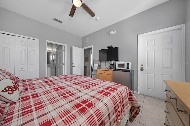 bedroom featuring a closet, visible vents, a ceiling fan, and light tile patterned floors