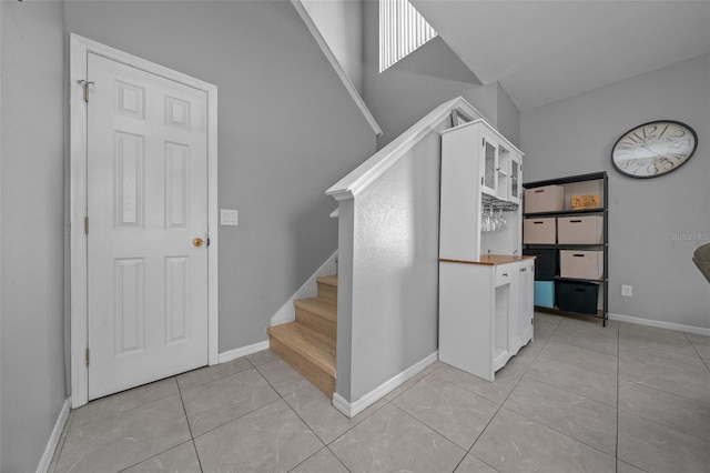 staircase featuring tile patterned floors and baseboards