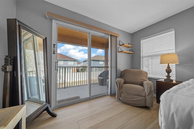 bedroom with access to exterior and wood finished floors