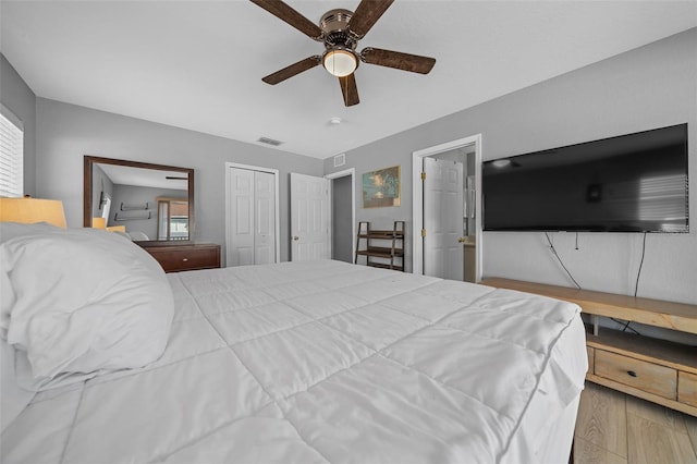 bedroom featuring visible vents, a closet, wood finished floors, and a ceiling fan