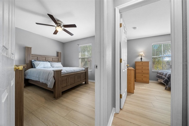 bedroom featuring baseboards, a ceiling fan, and light wood finished floors