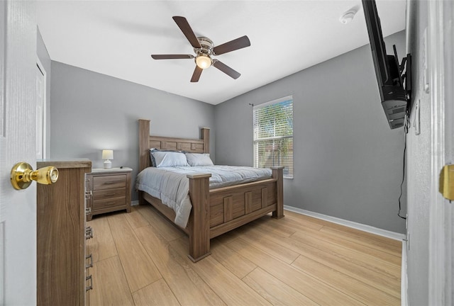 bedroom featuring ceiling fan, baseboards, and light wood-style flooring