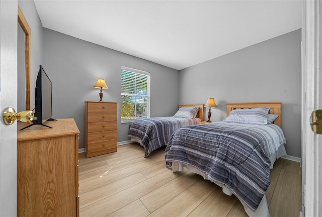 bedroom with light wood-style floors and baseboards