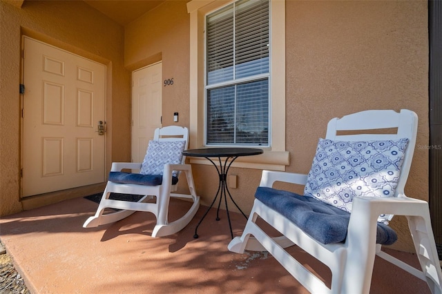 entrance to property with a porch and stucco siding