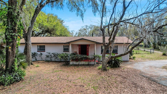 single story home with driveway, fence, and stucco siding