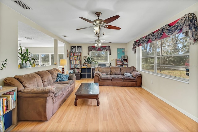 living area featuring baseboards, visible vents, and light wood-style floors