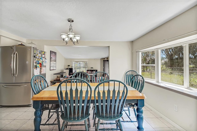 dining space featuring baseboards, a healthy amount of sunlight, an inviting chandelier, and light tile patterned floors