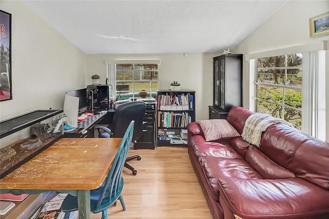 home office with vaulted ceiling and wood finished floors