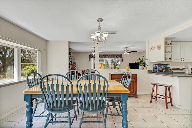 dining area featuring light tile patterned floors, ceiling fan, a textured ceiling, and a wealth of natural light