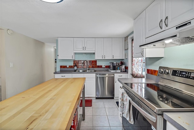 kitchen featuring appliances with stainless steel finishes, a sink, white cabinets, and under cabinet range hood