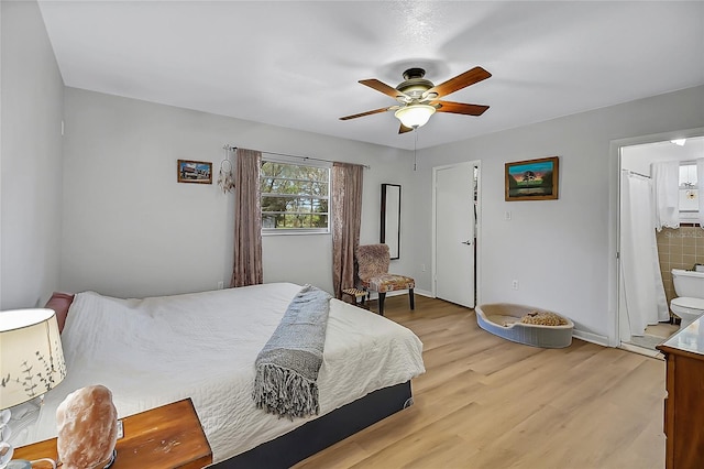 bedroom with a ceiling fan, light wood-style flooring, and ensuite bathroom