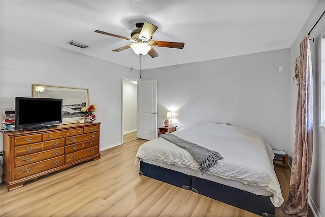 bedroom featuring a ceiling fan, baseboards, visible vents, and light wood finished floors