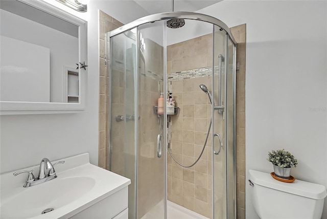 bathroom featuring a stall shower, vanity, and toilet