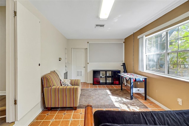 living area with tile patterned flooring, visible vents, and baseboards