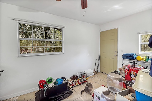 interior space featuring ceiling fan, baseboards, and light tile patterned floors