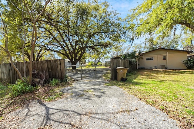 view of street with driveway, a gated entry, and a gate