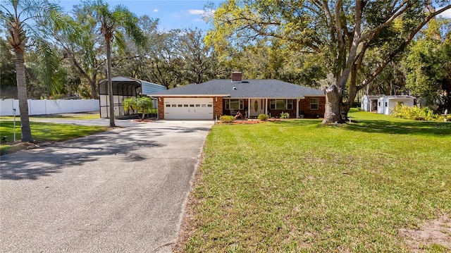 ranch-style home with aphalt driveway, an attached garage, brick siding, fence, and a front yard