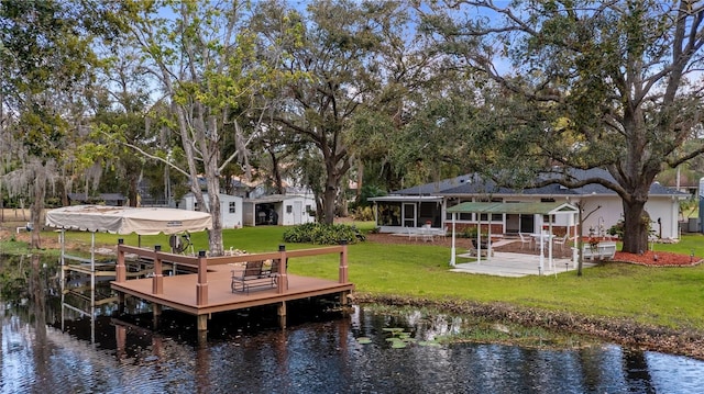 dock area featuring a water view, a lawn, and a patio