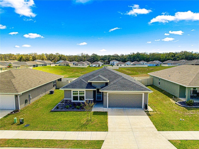 ranch-style house featuring an attached garage, driveway, roof with shingles, a residential view, and a front lawn