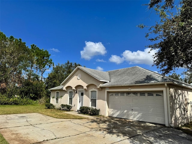 ranch-style house with an attached garage, a shingled roof, concrete driveway, stucco siding, and a front yard