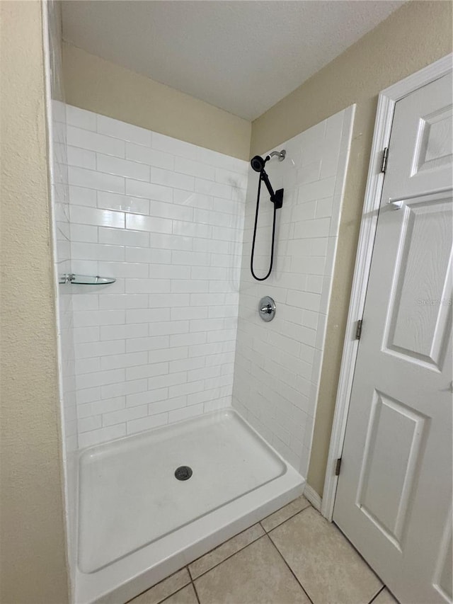 bathroom with a stall shower and tile patterned floors