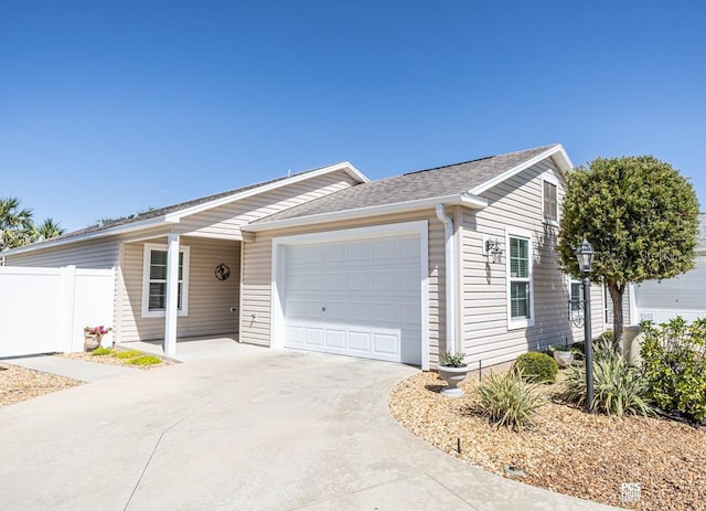 single story home with a garage, roof with shingles, fence, and driveway