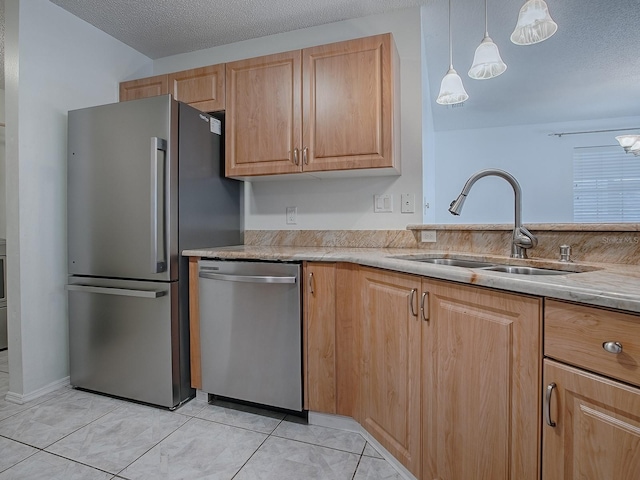 kitchen featuring appliances with stainless steel finishes, a sink, a textured ceiling, and light tile patterned floors