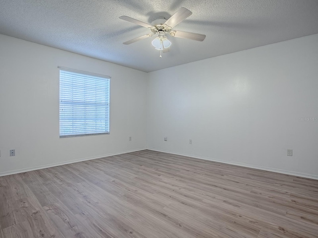 unfurnished room with a ceiling fan, baseboards, a textured ceiling, and light wood finished floors