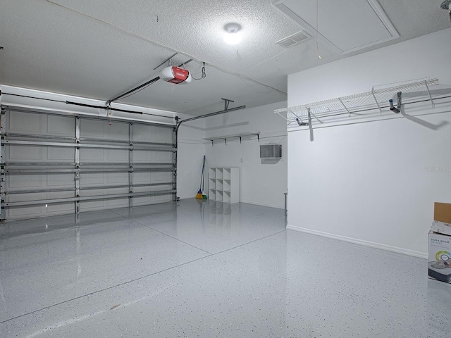 garage with baseboards, visible vents, and a garage door opener