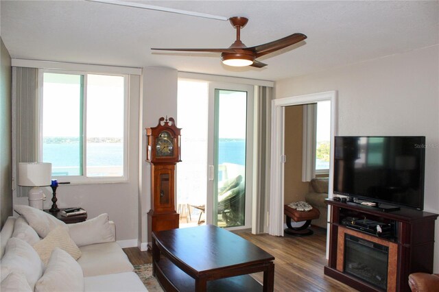 living room with dark wood-style floors and a ceiling fan