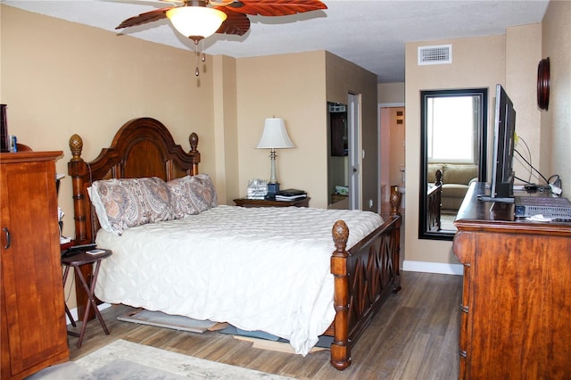 bedroom featuring ceiling fan, dark wood finished floors, visible vents, and baseboards