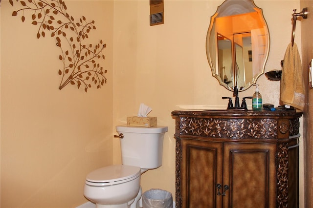 half bathroom featuring toilet, visible vents, and vanity