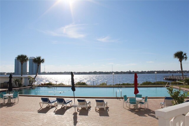 community pool with a water view and a patio