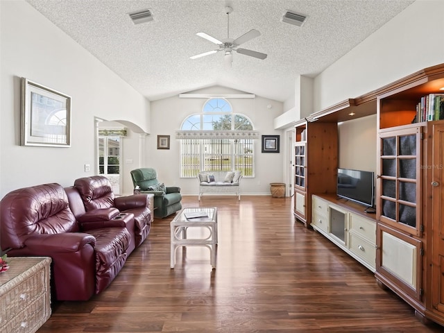 living area featuring arched walkways, dark wood-style flooring, visible vents, a ceiling fan, and vaulted ceiling