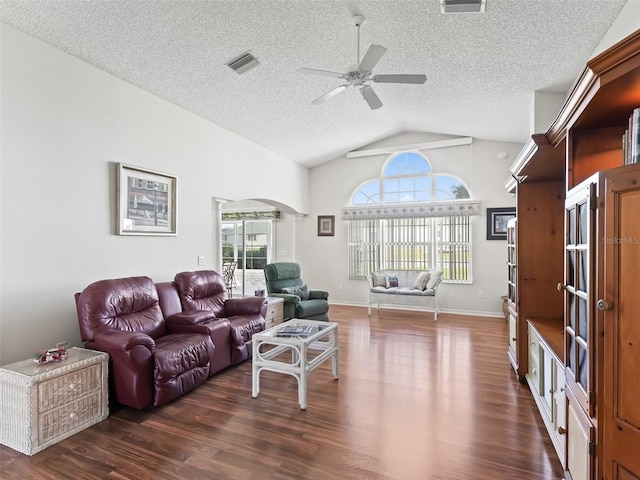 living area with arched walkways, ceiling fan, a textured ceiling, visible vents, and dark wood finished floors