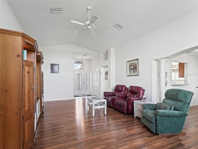 living room featuring lofted ceiling, plenty of natural light, visible vents, and dark wood-style flooring