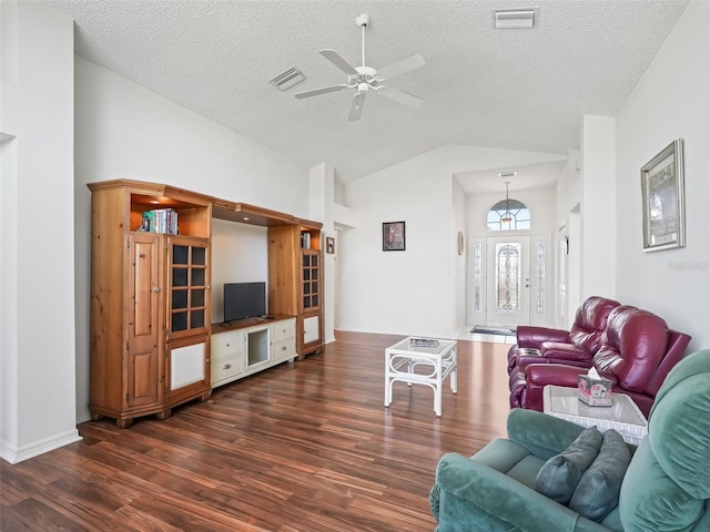 living room featuring dark wood-type flooring, visible vents, ceiling fan, and a textured ceiling