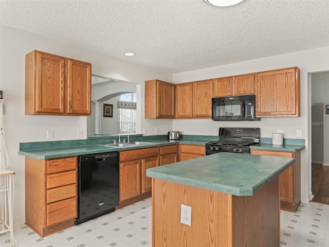 kitchen featuring light floors, dark countertops, a sink, and black appliances