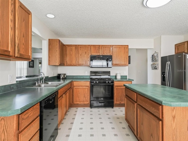 kitchen featuring dark countertops, brown cabinets, light floors, black appliances, and a sink