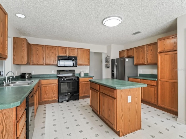 kitchen featuring black appliances, light floors, a sink, and brown cabinets