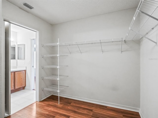 walk in closet featuring visible vents and wood finished floors