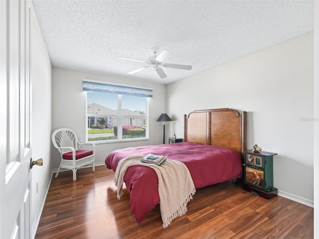 bedroom featuring a textured ceiling, wood finished floors, and baseboards