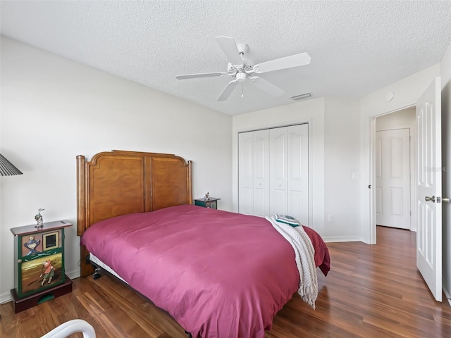 bedroom with a closet, visible vents, a ceiling fan, a textured ceiling, and wood finished floors