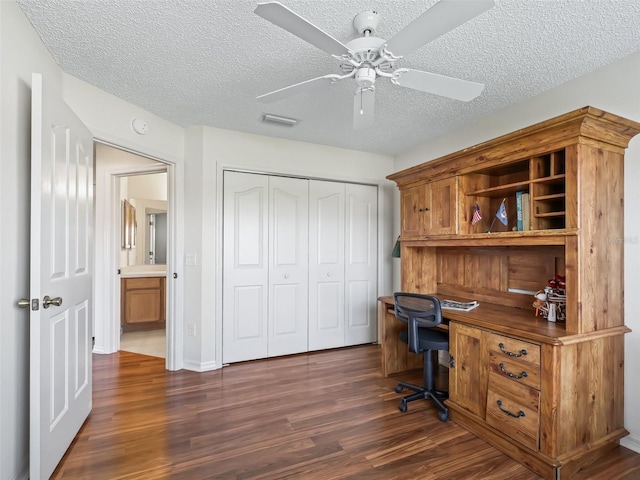 office area featuring dark wood-style floors, visible vents, ceiling fan, and a textured ceiling