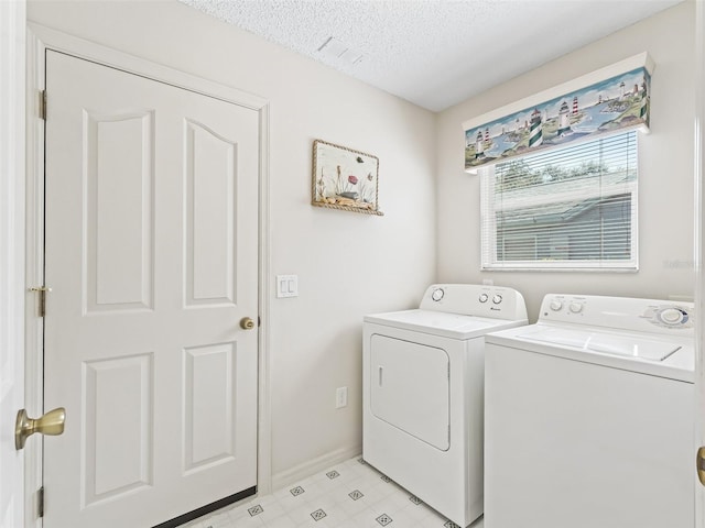 washroom with a textured ceiling, laundry area, visible vents, baseboards, and washer and clothes dryer