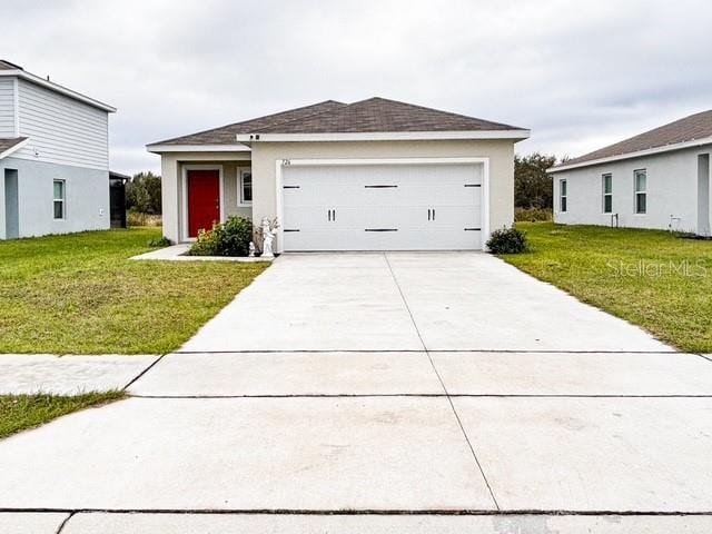 view of front of home with a garage, driveway, a front lawn, and a shingled roof