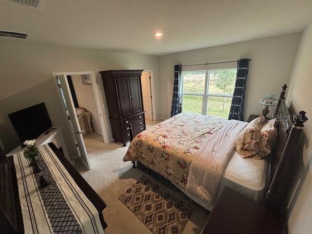 bedroom featuring light carpet and visible vents