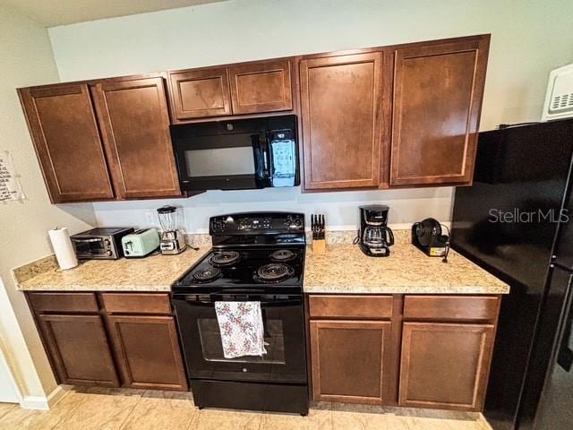 kitchen featuring black appliances and light stone counters