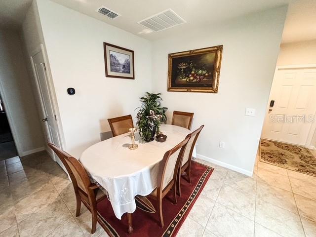 dining area featuring visible vents, baseboards, and light tile patterned floors